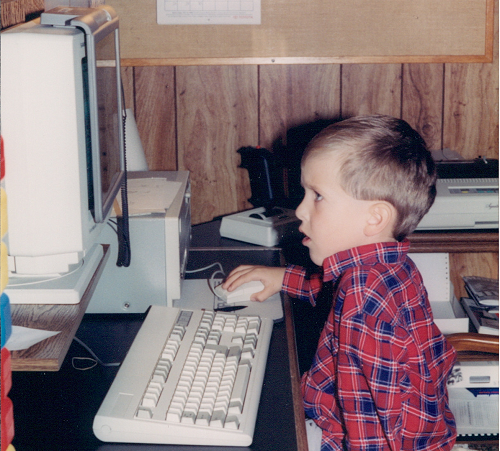 Image of author as a child in front of an old computer.